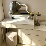 The Modern White Dressing Table is an elegant and functional bedroom furniture piece designed to provide a stylish space for grooming, makeup, and personal organization. Featuring a sleek white finish and a contemporary design, this dressing table adds a clean and sophisticated look to bedrooms, apartments, dressing rooms, and guest spaces. Made from high-quality materials, the dressing table is built for durability and everyday use. Its spacious tabletop provides enough room for cosmetics, perfumes, jewelry, skincare products, and decorative accessories, while the storage drawers help keep personal items neatly arranged and easily accessible. The smooth white surface is easy to clean and maintain, ensuring a fresh and attractive appearance for years. Designed to complement modern, minimalist, and contemporary interiors, the Modern White Dressing Table combines beauty, practicality, and storage convenience. It is an ideal choice for homeowners looking to create an organized and stylish personal grooming area. Key Features Elegant modern white finish Spacious tabletop for beauty essentials Multiple drawers for organized storage Durable and sturdy construction Smooth, scratch-resistant surface Easy-to-clean and maintain design Compact and space-saving structure Ideal for bedrooms, dressing rooms, apartments, and guest rooms Complements modern and minimalist décor Built for long-lasting everyday use