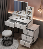 The White Dressing Table With Mirror is a stylish and practical bedroom furniture piece designed to provide a complete grooming and storage solution. Featuring an elegant white finish, spacious tabletop, built-in mirror, and convenient storage compartments, this dressing table adds beauty, organization, and functionality to modern bedrooms, apartments, dressing rooms, and guest spaces. Crafted from high-quality materials, the dressing table offers excellent durability and stability for everyday use. The large mirror provides a clear and comfortable view for makeup, hairstyling, and personal grooming, while the spacious drawers and compartments help keep cosmetics, jewelry, perfumes, skincare products, and accessories neatly organized. Its smooth white surface is easy to clean and maintains a fresh, elegant appearance. With its modern design and practical features, the White Dressing Table With Mirror complements contemporary, minimalist, and luxury bedroom interiors. It is the perfect choice for anyone looking to create a beautiful and organized personal grooming area. Key Features Elegant white modern finish Built-in mirror for convenient grooming Spacious tabletop for beauty essentials Multiple drawers and storage compartments Durable and stable construction Smooth, easy-to-clean surface Stylish design for modern bedrooms Ideal for cosmetics, jewelry, perfumes, and accessories Suitable for bedrooms, apartments, dressing rooms, and guest rooms Built for long-lasting everyday use